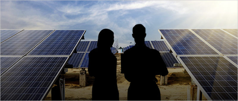dos personas frente a un parque solar