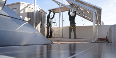 Dos instaladores montando paneles solares fotovoltaicos.