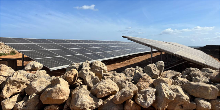 Parque solar fotovoltaico y un cielo azul con nubes.