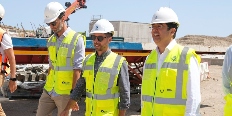 Tres hombres con casco en una obra.