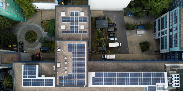 Vista aérea de un edificio con placas solares instaladas en la azotea.