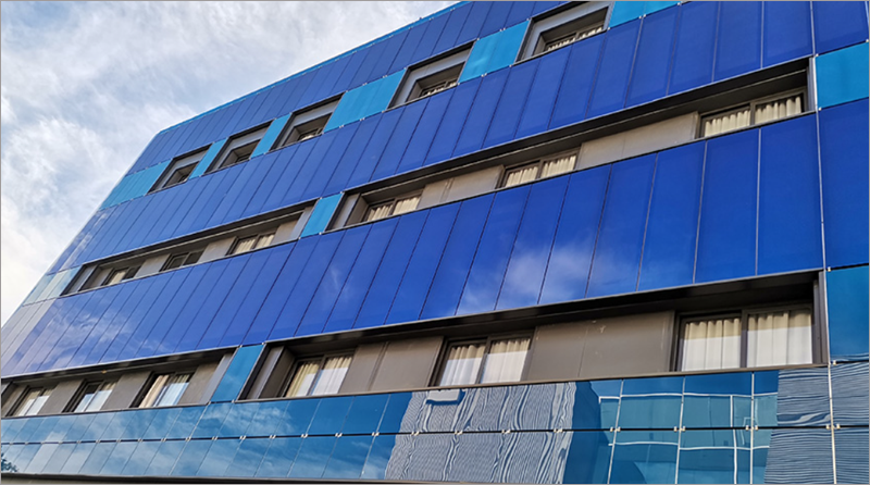 Fachada fotovoltaica de una residencia de estudiantes de Sevilla, con los paneles solares pintados del mismo color que el resto del edificio.