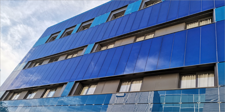 Fachada fotovoltaica de una residencia de estudiantes de Sevilla, con los paneles solares pintados del mismo color que el resto del edificio.