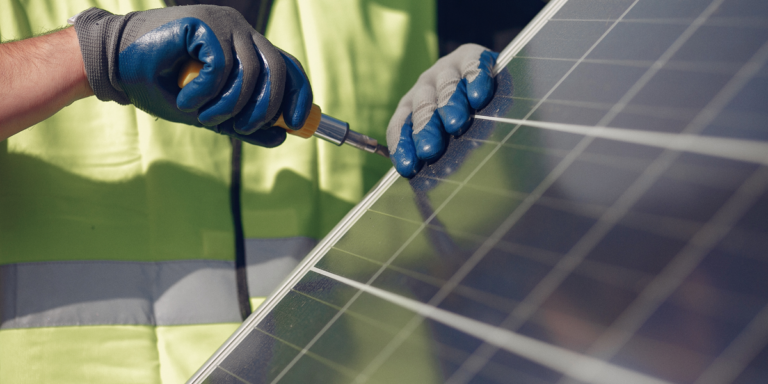 Imagen de un técnico con una placa solar extraída de un banco de imágenes.
