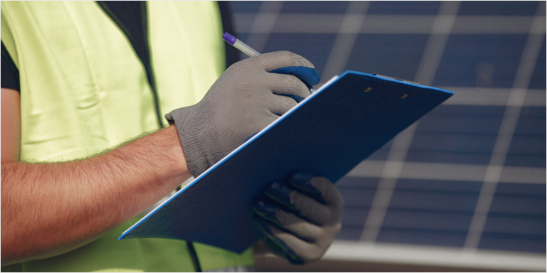 Foto de archivo de trabajador y paneles solares.