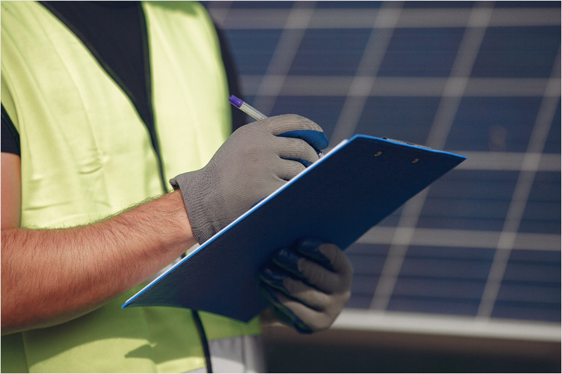 Foto de archivo de trabajador y paneles solares.